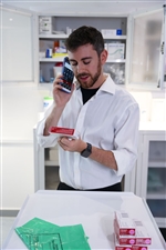 hc50-pharmacien-au-téléphone-regarde-étiquette-de-médicaments